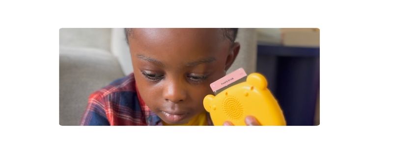 Child holding Tribal Tongue Talking Flashcards to his ear
