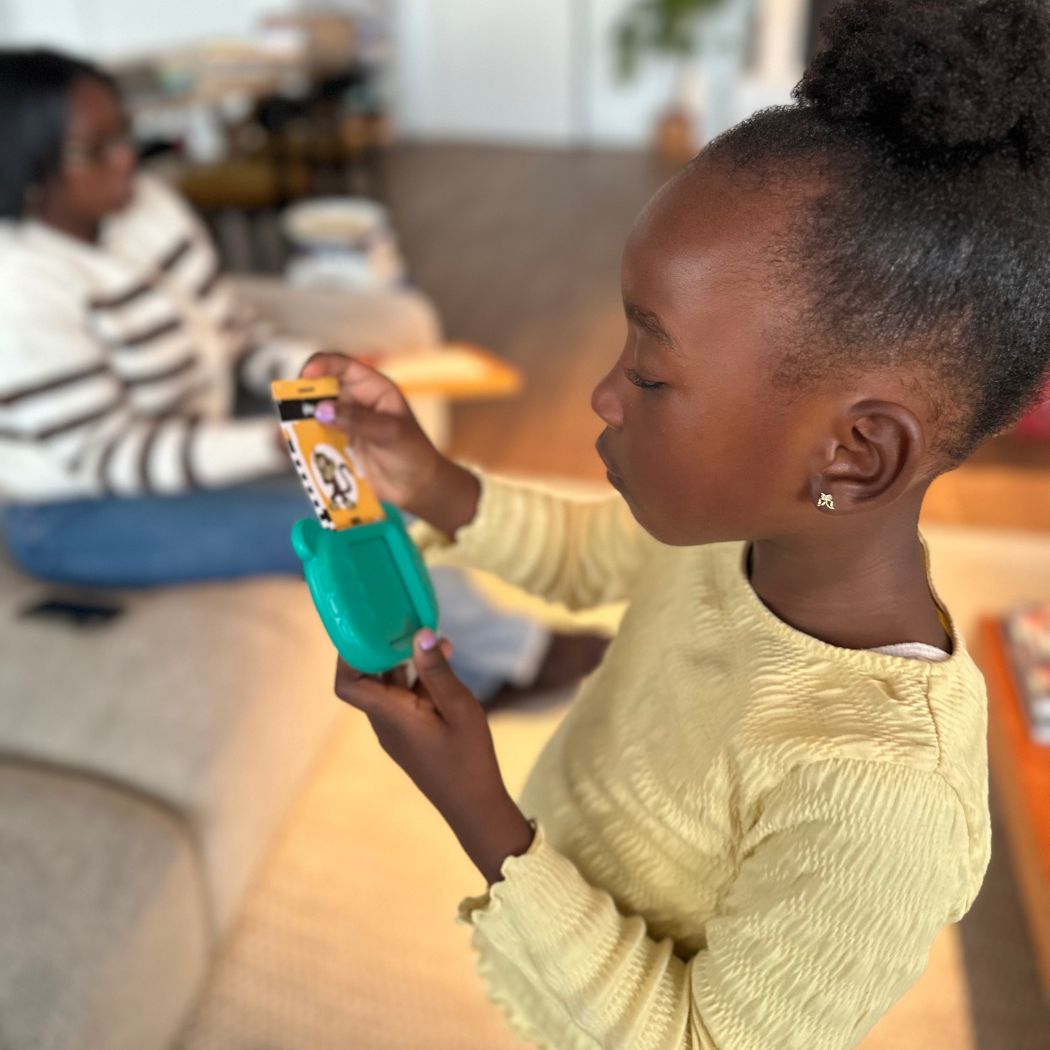 Young girl playing with Talking Flashcards in a casual indoor setting